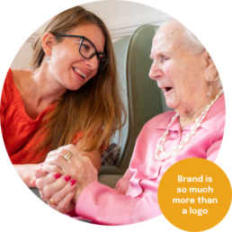 A carer enjoying time with a care home resident. Branding for care homes.